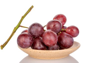 Seramik tabakta bir demet tatlı üzüm, makro, beyaz arka planda izole edilmiş..