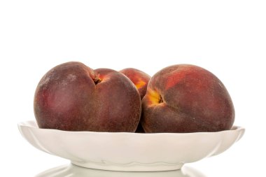 Beyaz seramik plakalı üç olgun şeftali, makro, beyaz arka planda izole edilmiş..