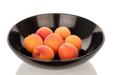 Beyaz arka planda izole edilmiş siyah seramik plakalı sulu kayısılar, makro.