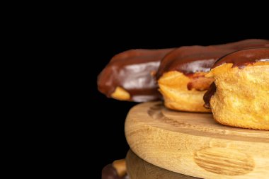 Tahta tepside kremalı üç eklem, makro, siyah arka planda izole edilmiş..