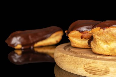 Tahta tepside kremalı üç eklem, makro, siyah arka planda izole edilmiş..