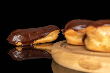 Tahta tepside kremalı üç eklem, makro, siyah arka planda izole edilmiş..