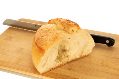 Beyaz ekmeğin yarısı, tahta mutfak tahtasının üzerinde bıçak, makro, beyaz arka planda izole edilmiş..