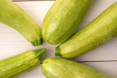 Ahşap bir masanın üzerinde birkaç olgun kabak, makro, üst manzara..