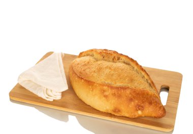 Ahşap mutfak tahtasında beyaz bir ekmek, makro, beyaz arka planda izole edilmiş..