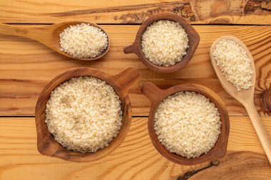 Tahta bir masada, ahşap bardaklarda yuvarlak pirinç, makro, üst manzara..