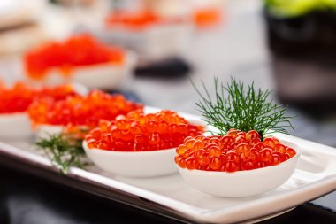 Restorandaki masada seramik tabakta kırmızı havyar, makro..