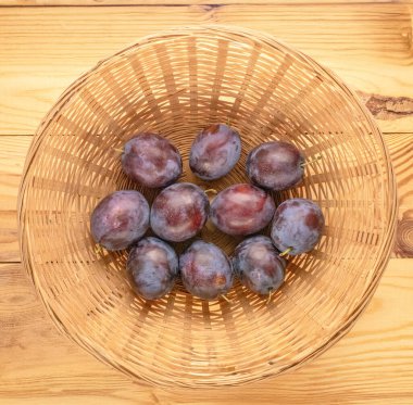 Tahta bir masada saman tabaktaki tatlı erikler, makro, üst manzara..