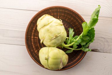 Tahta masada seramik tabakla taze kohlrabi lahanası, makro, üst manzara..