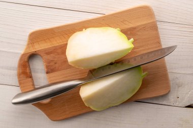 Tahta masa üzerinde ahşap mutfak tahtasıyla taze kohlrabi lahanası..