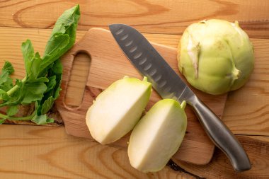 Tahta masa üzerinde ahşap mutfak tahtasıyla taze kohlrabi lahanası..