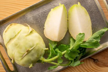 Taze olgun kohlrabi lahanası. Tahta tepside metal tepsi, makro, üst manzara..