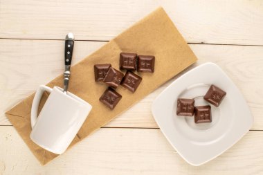 Ahşap bir masada seramik tabakları olan siyah çikolata, makro, üst manzara..