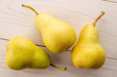 Tahta bir masada sulu sarı armutlar, üst manzara, makro.