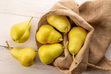 Tahta bir masada sulu sarı armutlar, üst manzara, makro.