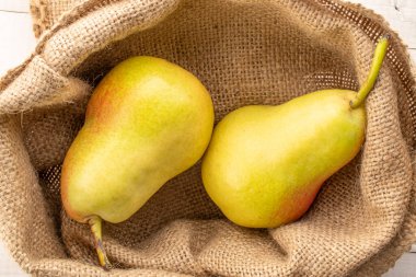 Jüt torbada sulu sarı armutlar, üst manzara, makro.