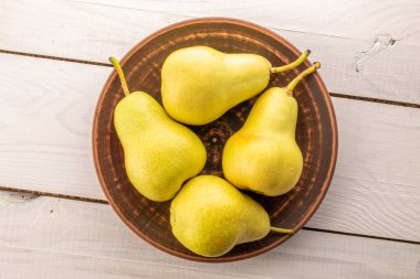 Tahta bir masada sulu sarı armutlar, üst manzara, makro.