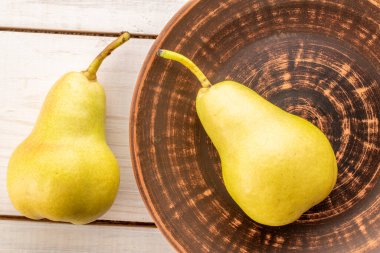 Tahta bir masada sulu sarı armutlar, üst manzara, makro.