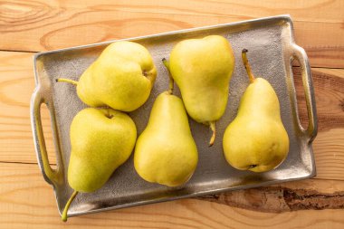 Tahta bir masada sulu sarı armutlar, üst manzara, makro.