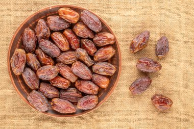 Jüt kumaş, makro, üst görünüm üzerinde kil plakalı birkaç tatlı kurumuş çukur hurma..