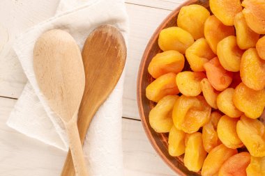 Ahşap bir masada ev yapımı tabakları olan kurutulmuş kayısılar, yakın çekim, üst manzara..