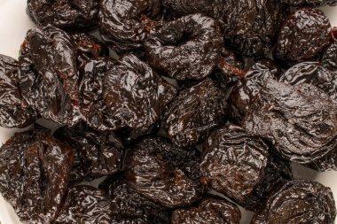 Seramik tabakta tatlı kuru erik, makro, üst manzara..