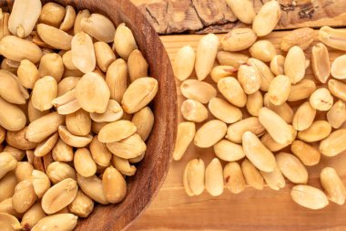 Soyulmuş, kavrulmuş fıstık, ahşap bir masa üzerinde ahşap kaplar, yakın plan, üst manzara..