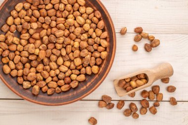 Kil tabakta fındıklar, tahta bir kaşık, kraft kağıdının üstünde, yakın plan, üst manzara..