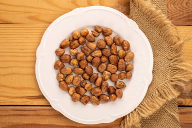 Tahta bir masada beyaz bir tabakta fındık, yakın plan, üst manzara..