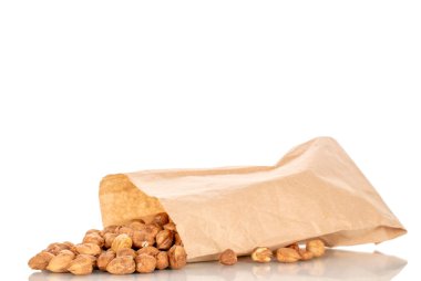 Kağıt torbalı birkaç fındık, yakın plan, beyaz arka planda izole edilmiş..
