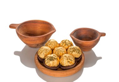 Tahta kaplamalı hediye kağıdına sarılı çikolatalı şekerler, yakın plan, beyaz arka planda izole edilmiş..