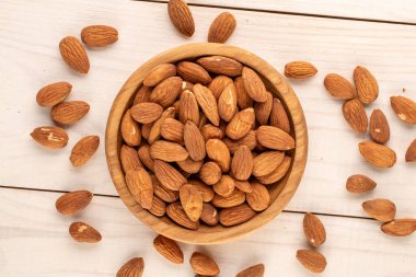 Ahşap bir masa üzerinde mutfak aletleri olan kavrulmuş bademler, yakın çekim, üst manzara..
