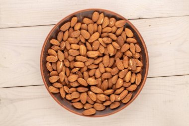 Ahşap bir masa üzerinde mutfak aletleri olan kavrulmuş bademler, yakın çekim, üst manzara..