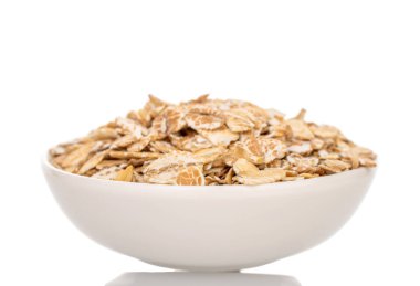 Yulaf ezmesi ev yapımı mutfak malzemeleriyle sarılmış, yakın plan, beyaz arka planda izole edilmiş.