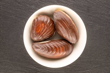 Birkaç çikolata şekeri ve seramik tabaklar kayrak taşı üzerinde, yakın plan, üst görünüm.