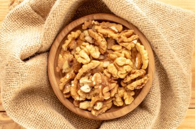 Ceviz kabuğu ve mutfak gereçleri jüt kumaş üzerinde, yakın plan, üst manzara..