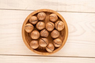 Kabuklu Macadamia fındıkları, ahşap masa, üst manzara..