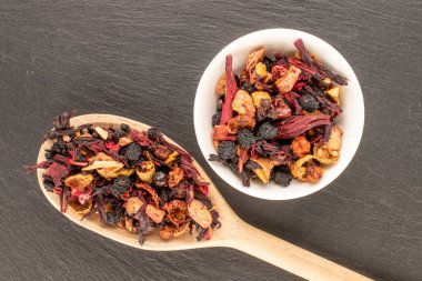 Seramik bir çanakta, tahta bir kaşıkla karpatya orman çayı. Tahta bir taş, makro, üst manzara..