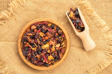 Ahşap bir tepside, tahta bir kaşıkla, jüt kumaşında, makroda, tepeden manzaralı Karpatya orman çayı..