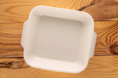 Bir seramik fırın tepsisi ahşap bir masada, yakın çekim, üst manzara.