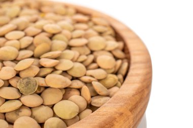 Tahta bir tabakta çiğ mercimek, beyaz arka planda izole, makro.