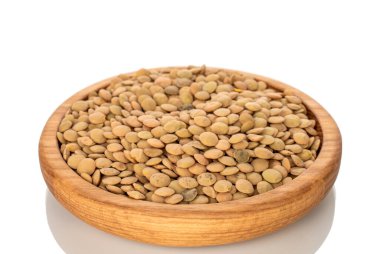 Tahta bir tabakta çiğ mercimek, beyaz arka planda izole, makro.