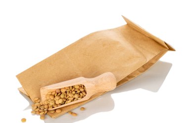 Tahta kaşık ve kağıt torbalı çiğ mercimek, beyaz arka planda izole edilmiş, makro..