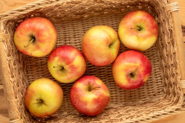 Tahta bir sepetin içinde birkaç organik elma, yakın plan, üst manzara..