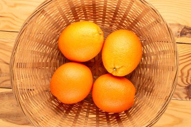 Tahta bir masada saman tabaktaki dört sulu portakal, yakın plan, üst manzara..