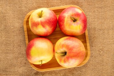 Dört organik elma ve jüt kumaş tepsisi, yakın plan, üst görüş..