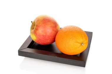 Bir olgun portakal ve elma siyah ahşap tepside, yakın plan, beyaz arka plan izole.