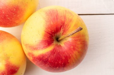 Tahta bir masada üç sulu elma, yakın plan, üst manzara..