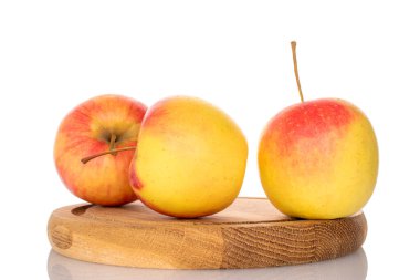 Tahta bir tepside üç elma, makro, beyaz bir arka planda izole edilmiş..