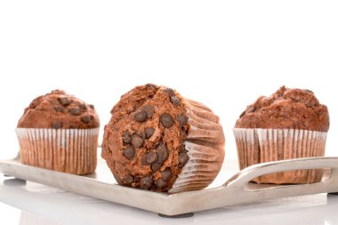 Metal tepside üç çikolatalı kek, beyaz arka planda izole edilmiş, yakın plan..